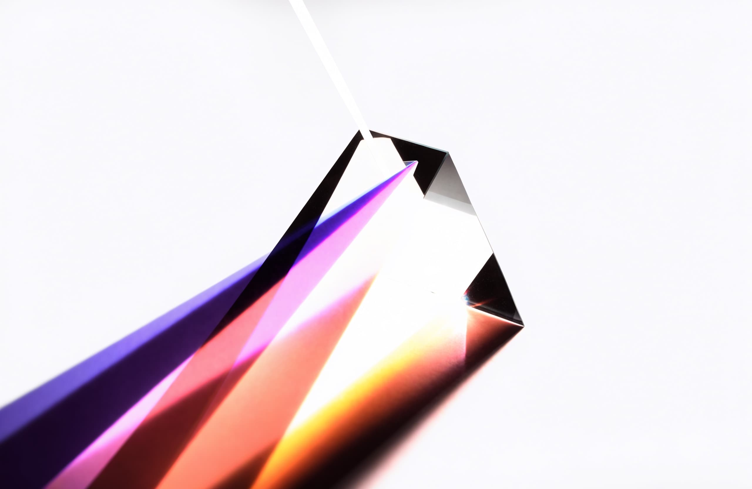 A beam of white light separating through a prism into distinct coloured bands.
